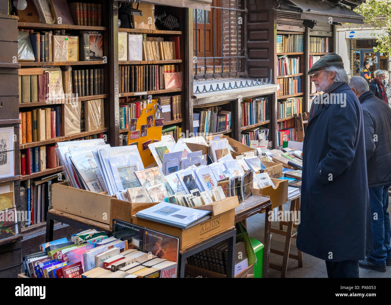 Man surfen Bücher auf einen Stall Verkauf second hand Bücher und Kunstdrucke, Calle del Arenal, Madrid, Spanien Stockfoto