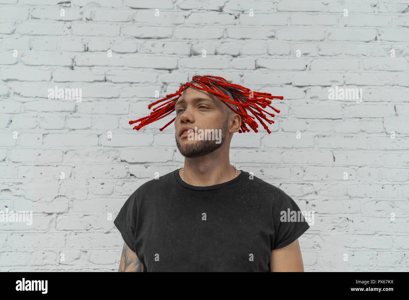Jungen attraktiven Mann mit roten Dreadlocks schüttelte seine Haare. Stockfoto