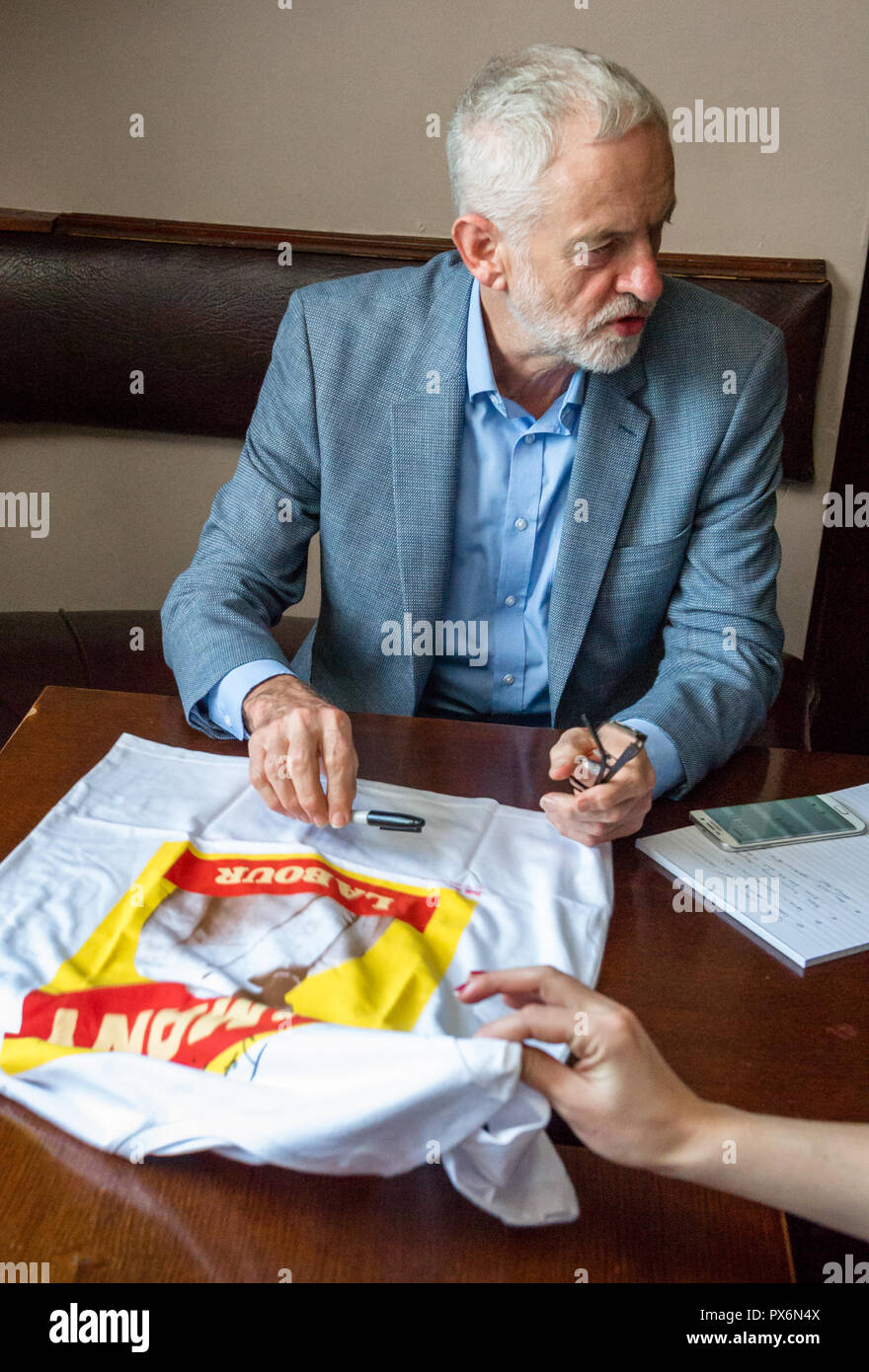 Jemery Corbyn Führer der Labour Party sat Autographierend ein T-Shirt. Stockfoto