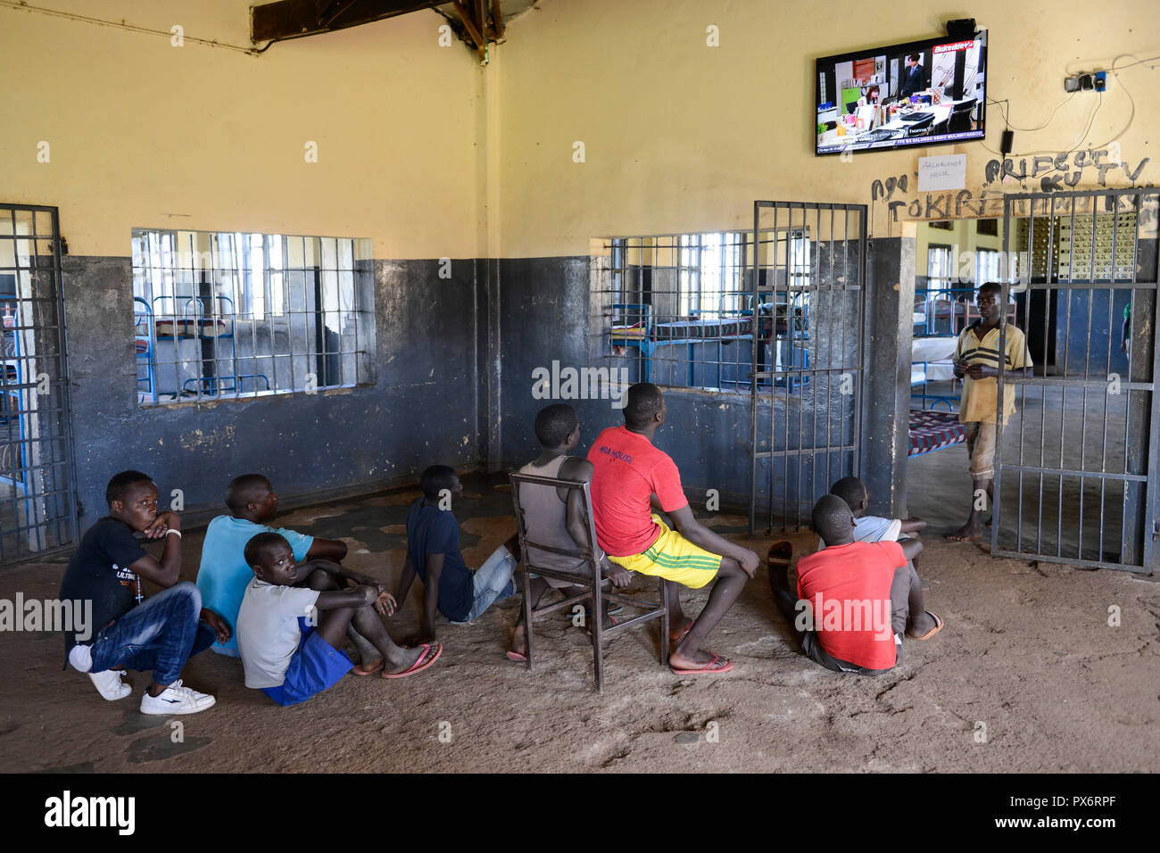 UGANDA, Kampala, Kampiringisa, national Rehabilitation Center, ein Jugendlicher - Gefangenenlager für Kinder und Jugendliche, schlafen Zimmer mit Fernseher an der Wand/Jugendhaftanstalt und Rehabilitationszentrum Kampiringisa, Schlafsaal Stockfoto