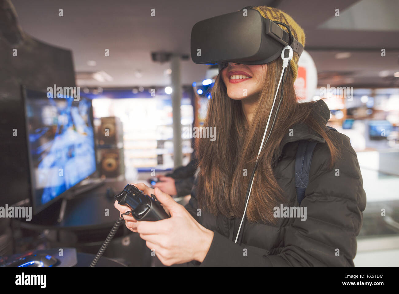 Die Frau ist, die versucht, eine virtuelle Realität gerät in einem Einzelhandel für Unterhaltungselektronik Stockfoto