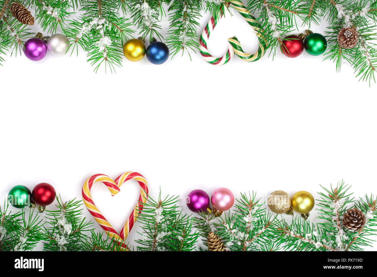 Weihnachten Rahmen der Fir Tree Branch mit Zuckerstangen und Kugeln auf weißem Hintergrund mit Kopie Platz für Ihren Text isoliert. Ansicht von oben. Stockfoto