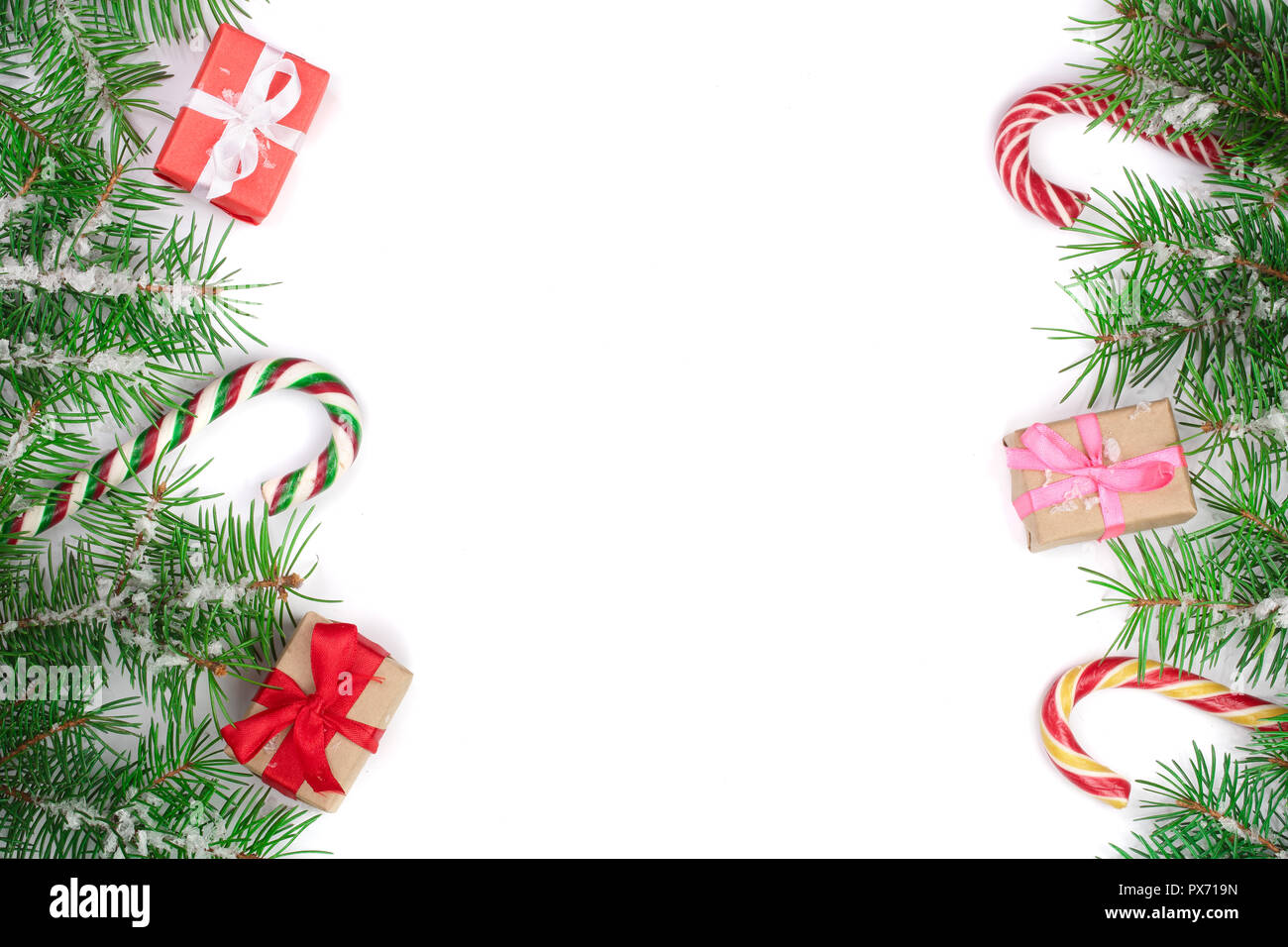 Weihnachten Rahmen der Fir Tree Branch mit Zuckerstangen und Boxen auf weißem Hintergrund mit Kopie Platz für Ihren Text isoliert. Ansicht von oben. Stockfoto