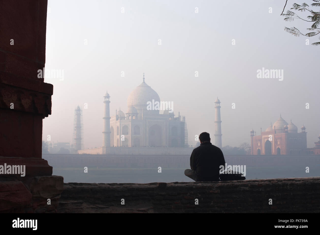 Taj Mahal die Wunder der Welt und der Stolz von Indien im Winter morgen weichen warmen Licht mit Dunst und durch einen männlichen Touristen vor beobachtet Stockfoto