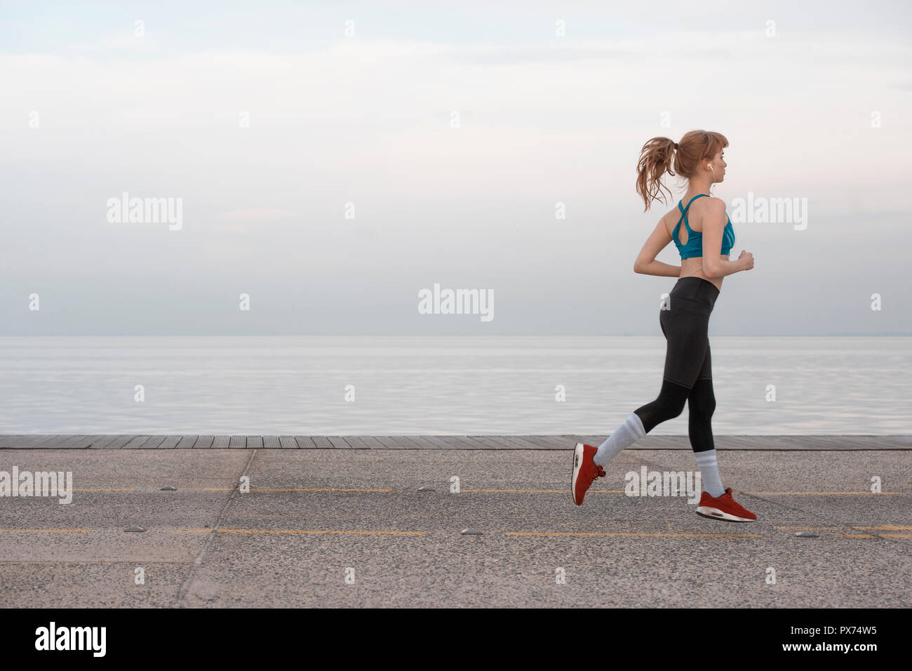 Eine Frau joggen am Meer, in der Stadt Umgebung Stockfoto