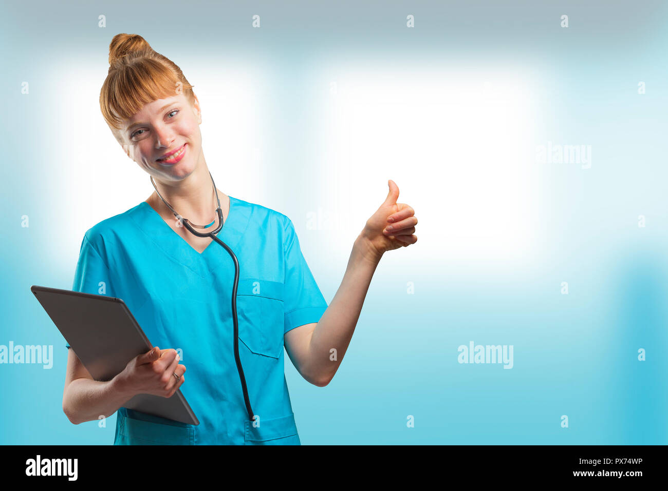 Schönen Frau, eine Krankenschwester oder der Arzt mit roten Haaren, mit Daumen nach oben posiert während eines Tablet-PC Stockfoto
