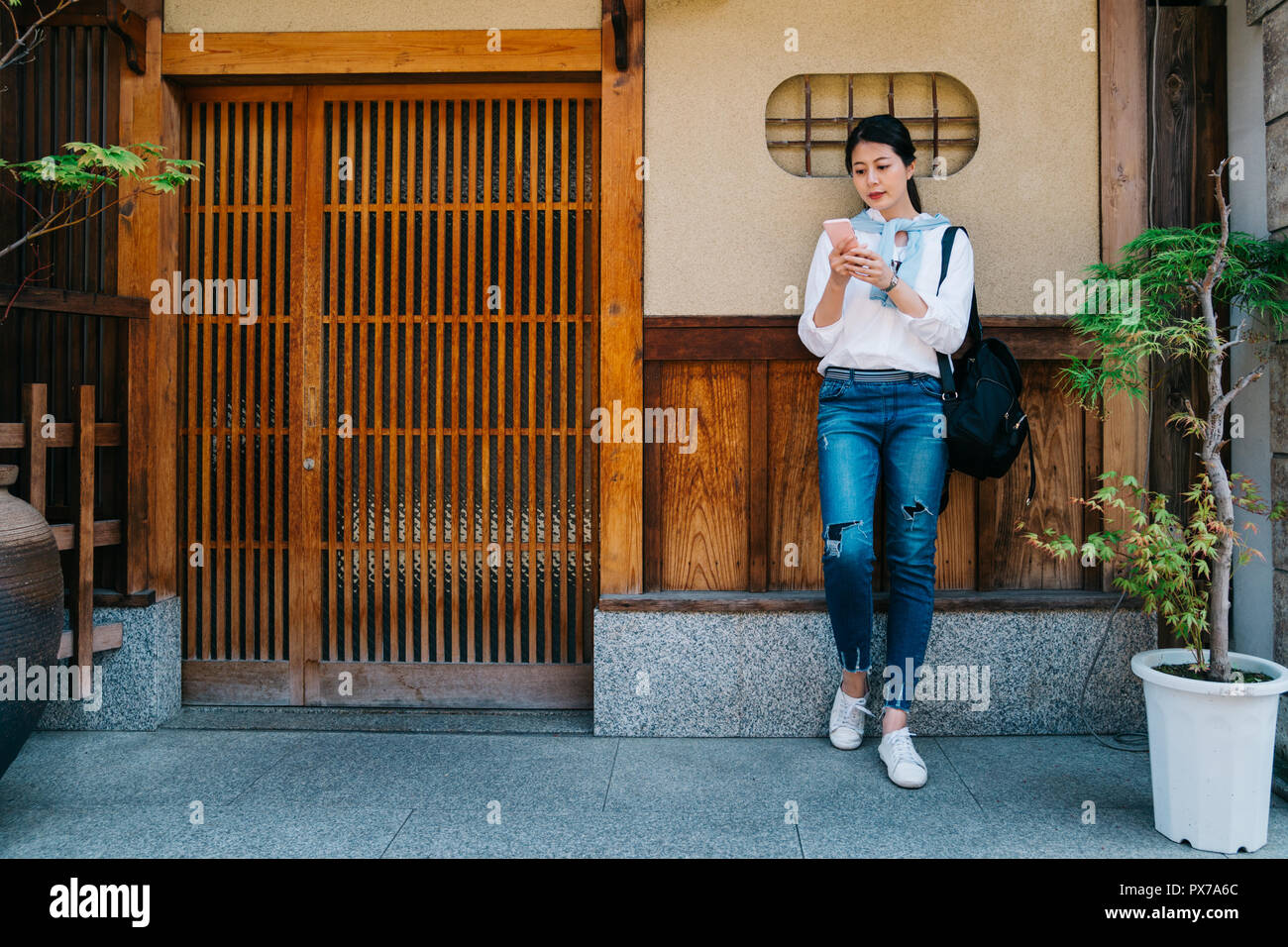 Elegante Dame wartet ihr Freund vor seinem Haus und ihn. Büro in Japan Dame in Urlaub Lifestyle. stehendes Mädchen vor Holz Stockfoto