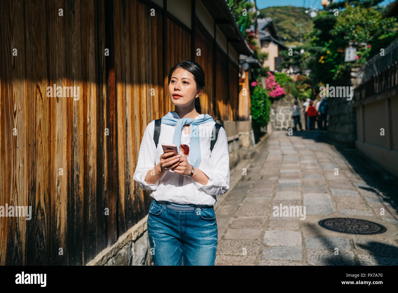 Traveler ist das Lesen der Anleitung durch ihr Handy während der berühmten japanischen Stadt besuchen. Mädchen Tourist können Sie über online Karte Suche nach Richtung, während in Japan Stockfoto