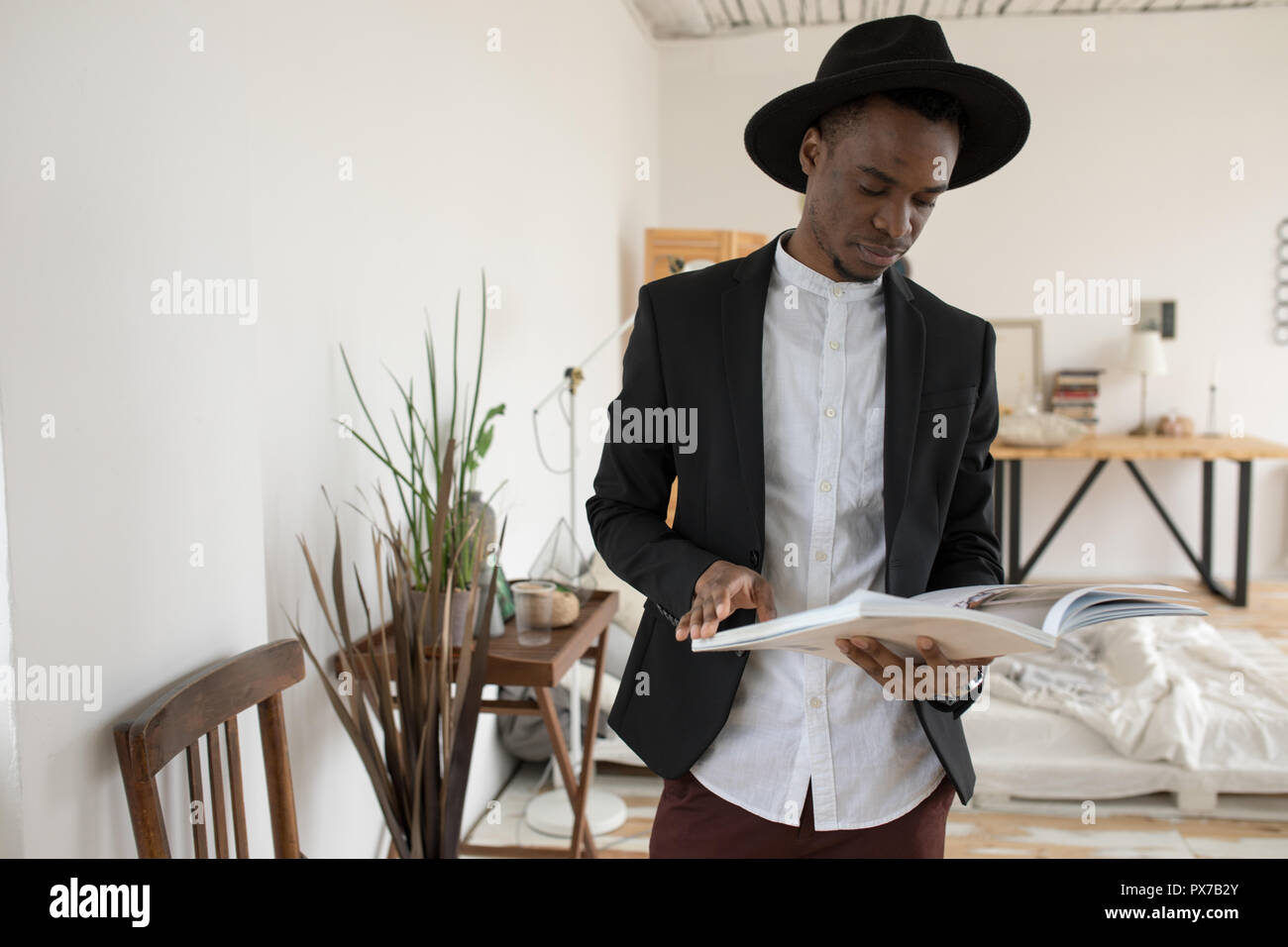 Afrikanischer amerikanischer Mann in einen Hut stehend mit einem Buch. Stockfoto