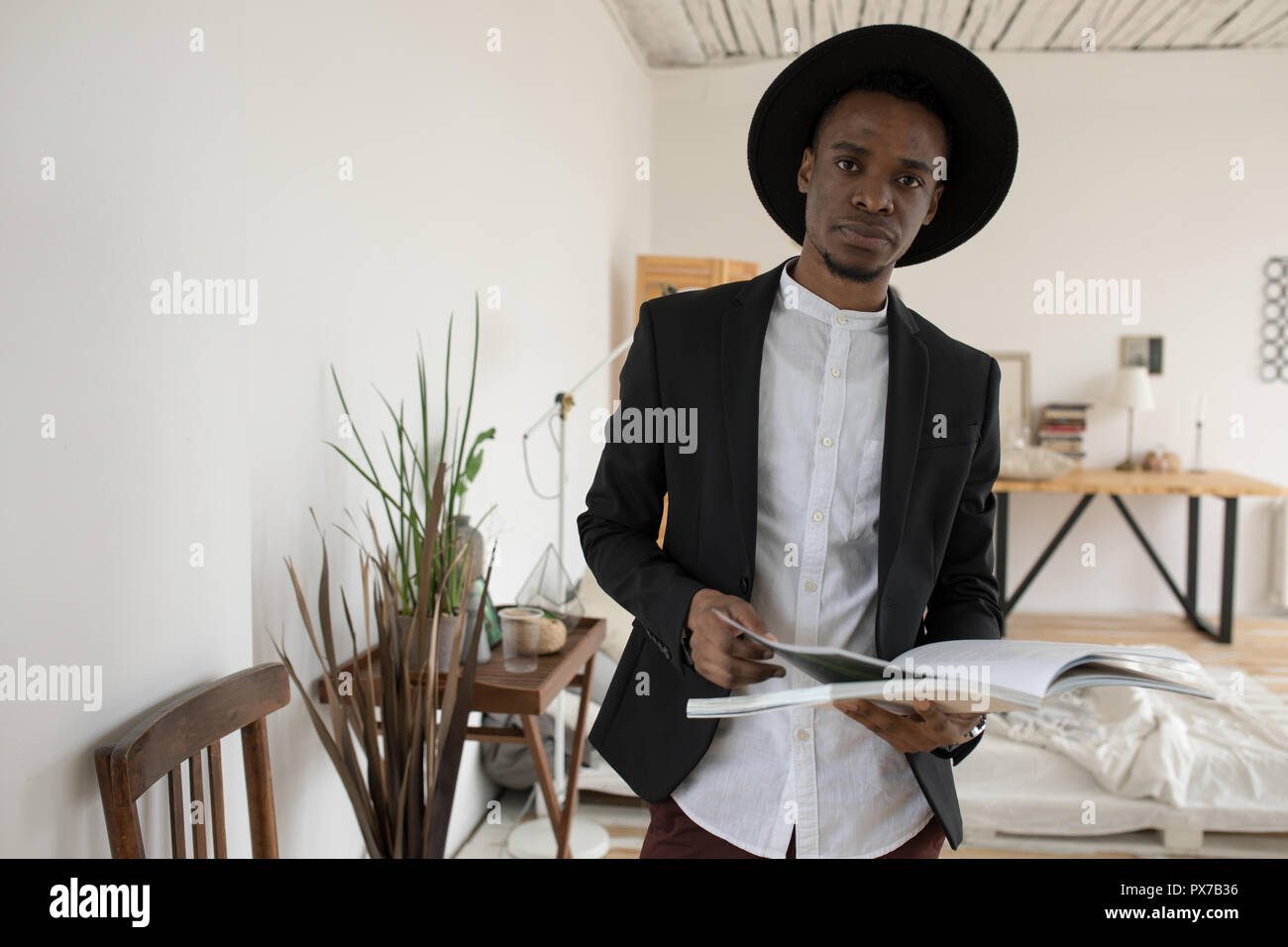 Afrikanischer amerikanischer Mann in einen Hut stehend mit einem Buch. Stockfoto