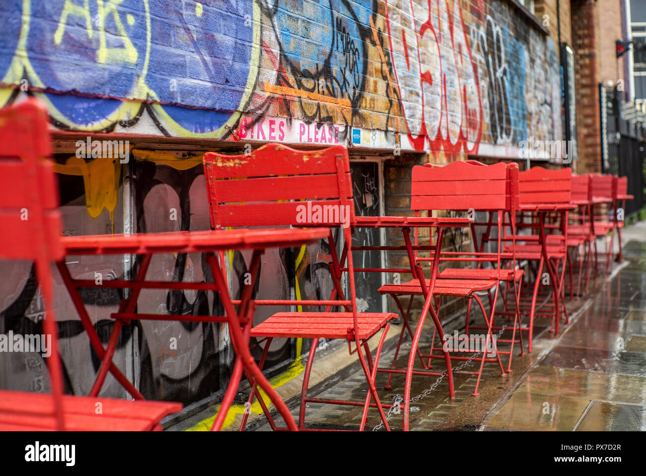 Bunte rote Stühle in den Straßen von London unter einer leichten Regen - 3. Stockfoto