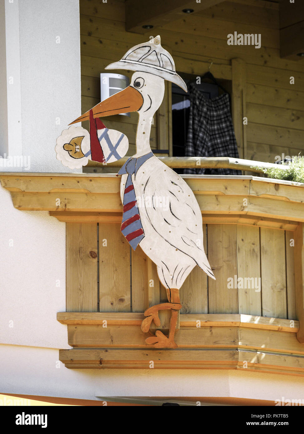 Lustige Storch aus Holz mit einem Baby in seiner Pecker Stockfotografie