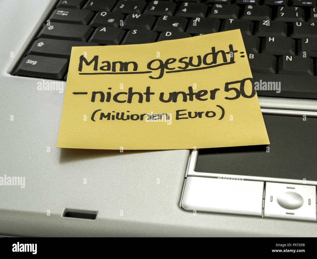 Memo-Hinweis auf Notebook, Suche einen Mann, nicht unter fünfzig (Mio. Euro) Stockfoto