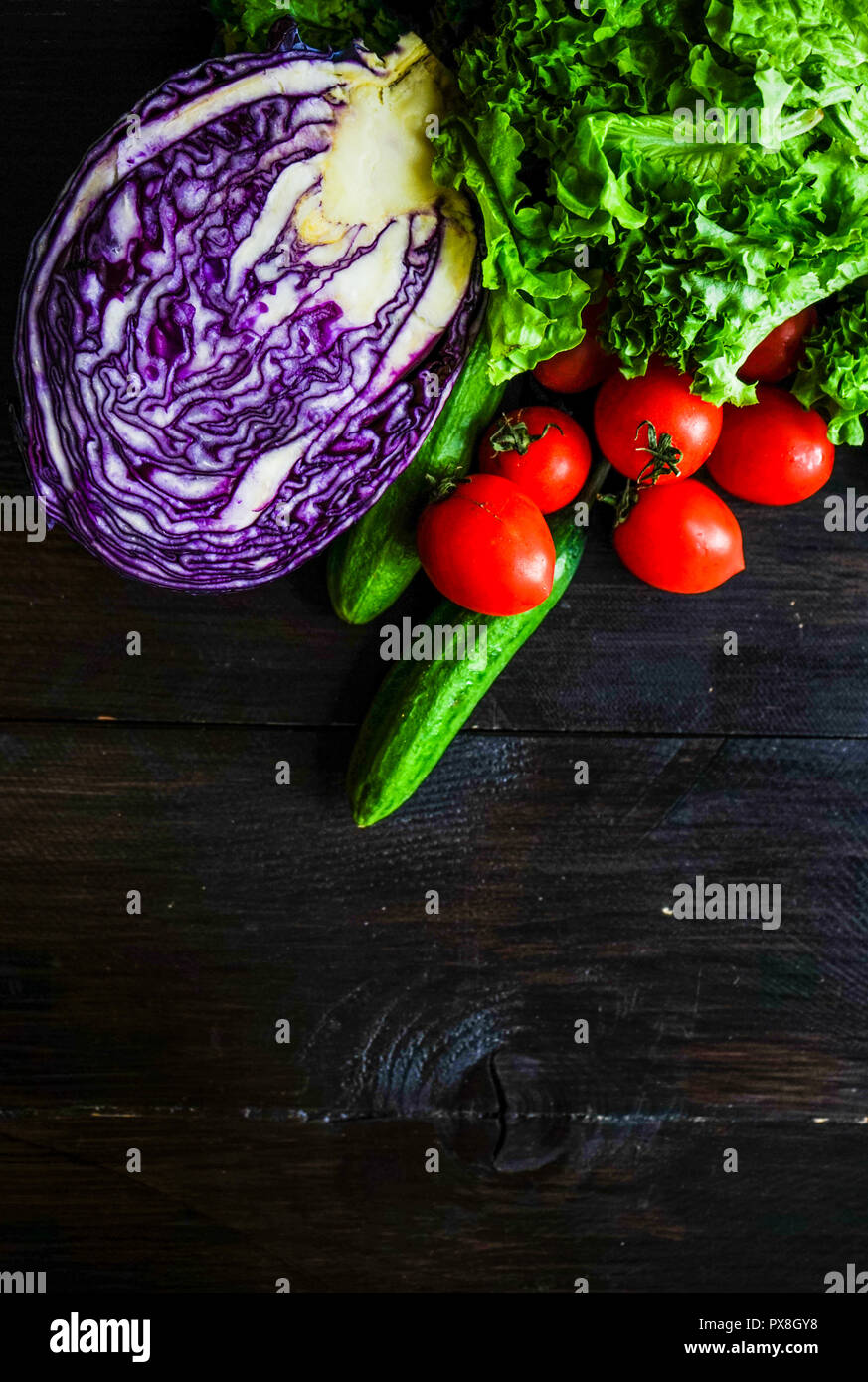 Oraganic Gemüse wie Gurken, Cherry Tomaten, Kopfsalat und Kohl als Salat inredients auf rustikalen Hintergrund mit Kopie Raum Stockfoto