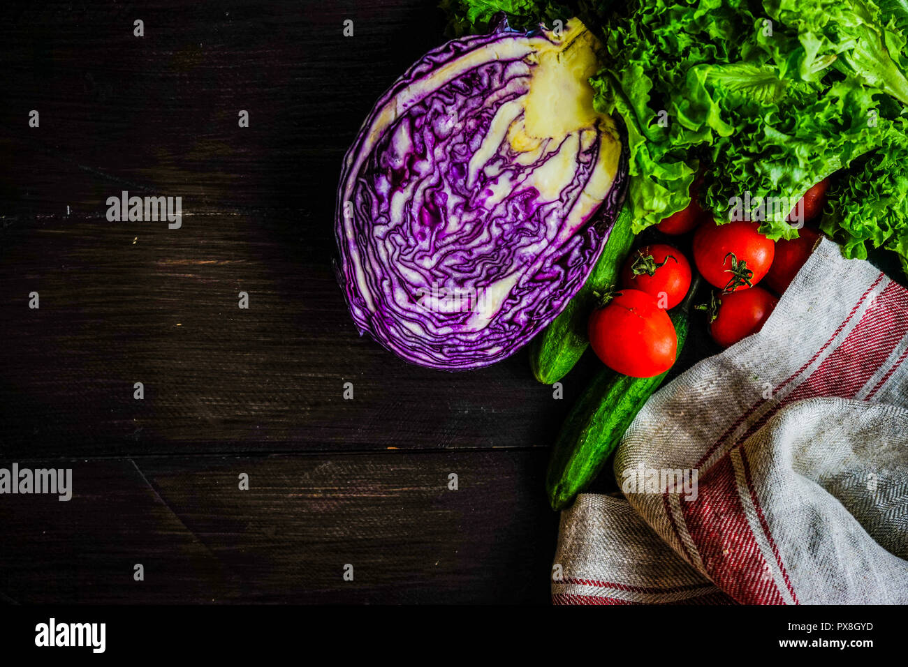 Oraganic Gemüse wie Gurken, Cherry Tomaten, Kopfsalat und Kohl als Salat inredients auf rustikalen Hintergrund mit Kopie Raum Stockfoto