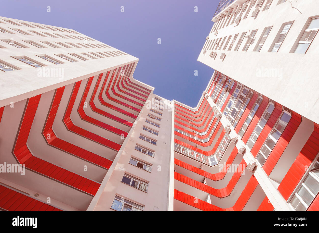 Anzeigen eines Wohnhauses von unten nach oben. Weißes Haus mit roten Balkone in einem warmen sonnigen Tag Stockfoto