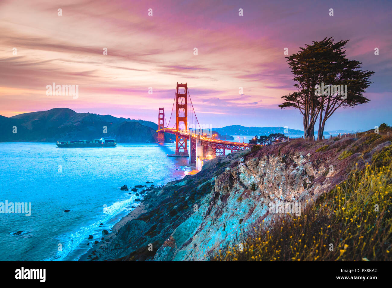 Classic panorama Blick auf die berühmte Golden Gate Bridge vom malerischen Baker Beach in schönen Post Sonnenuntergang Dämmerung mit blauem Himmel und Wolken bei Sonnenuntergang gesehen in Stockfoto