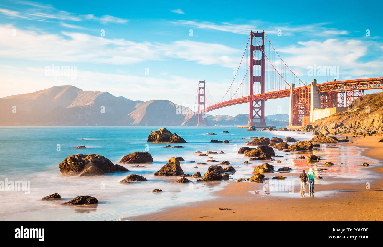 Klassische Panoramablick auf die berühmte Golden Gate Bridge vom malerischen Baker Beach in wunderschönen goldenen Abendlicht gesehen an einem sonnigen Tag mit blauen Himmel und Cl Stockfoto