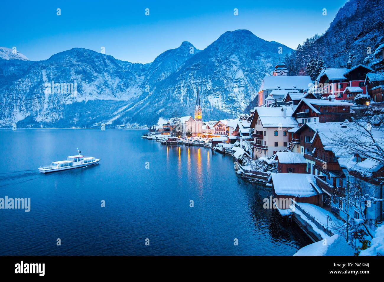 Klassische Postkarte Blick auf berühmte Hallstatt Stadt am See in den Alpen mit traditionellen Passagierschiff auf schönen Hallstattersee in mystischer Dämmerung d Stockfoto