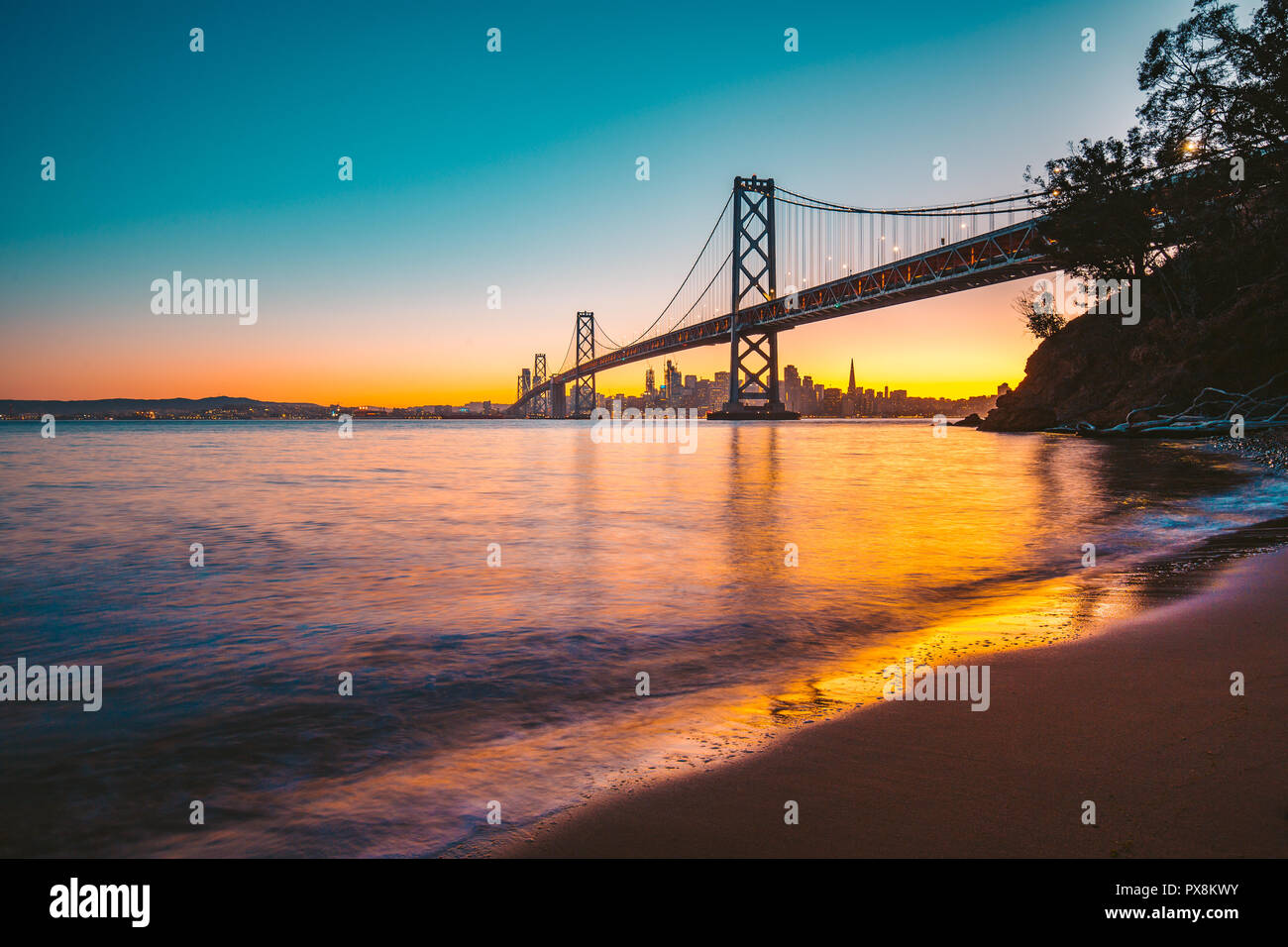 Klassische Panorama des berühmten Oakland Bay Bridge mit der Skyline von San Francisco mit Sonnenuntergang im Sommer in schönen Dämmerung beleuchtet Stockfoto