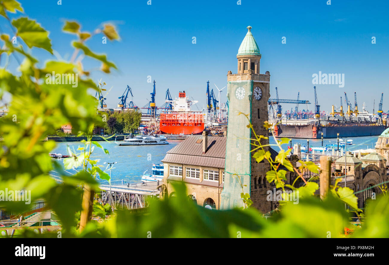 Berühmte Hamburger Landungsbrücken mit kommerziellen Hafen und Elbe mit blauem Himmel und Wolken im Sommer, St. Pauli, Hamburg, Deutschland Stockfoto