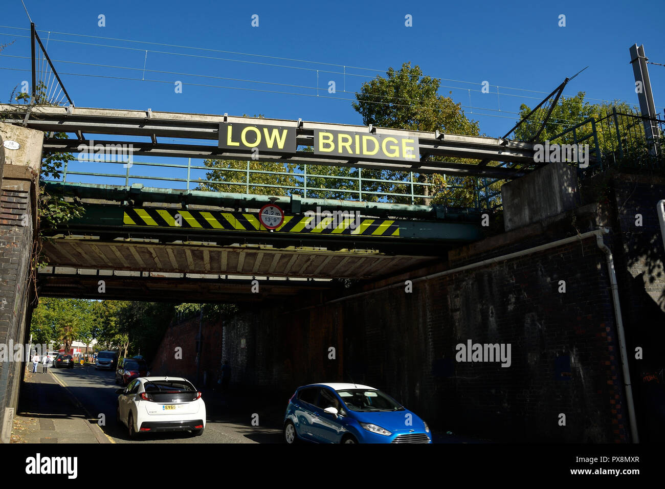 Niedrige Brücke Zeichen auf einer Eisenbahnbrücke über die Mill Street in Crewe, Großbritannien Stockfoto