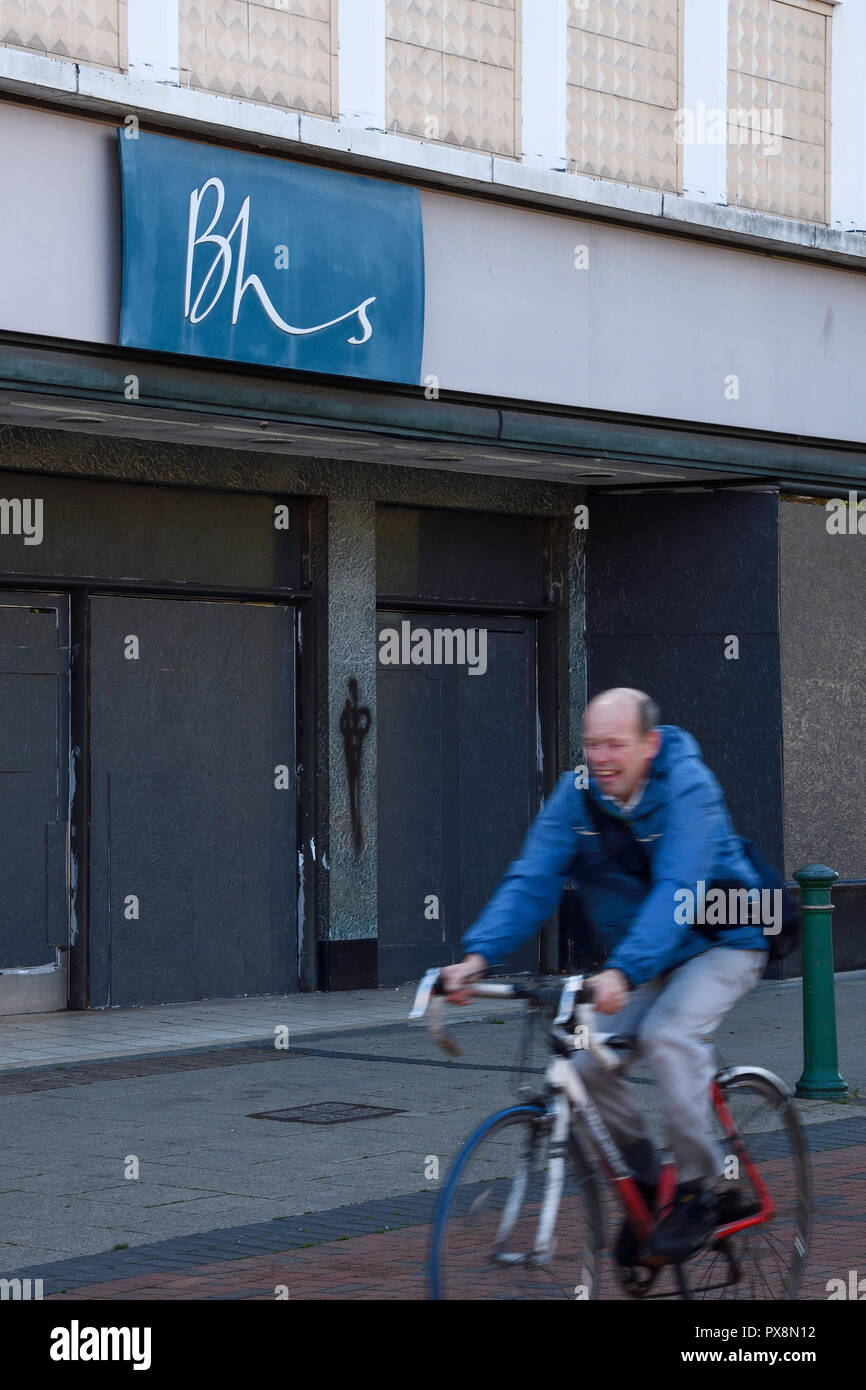 Ein Mann Zyklen hinter einem Geentert, BHS-Store an der Victoria Street in Crewe Stadtzentrum UK Stockfoto
