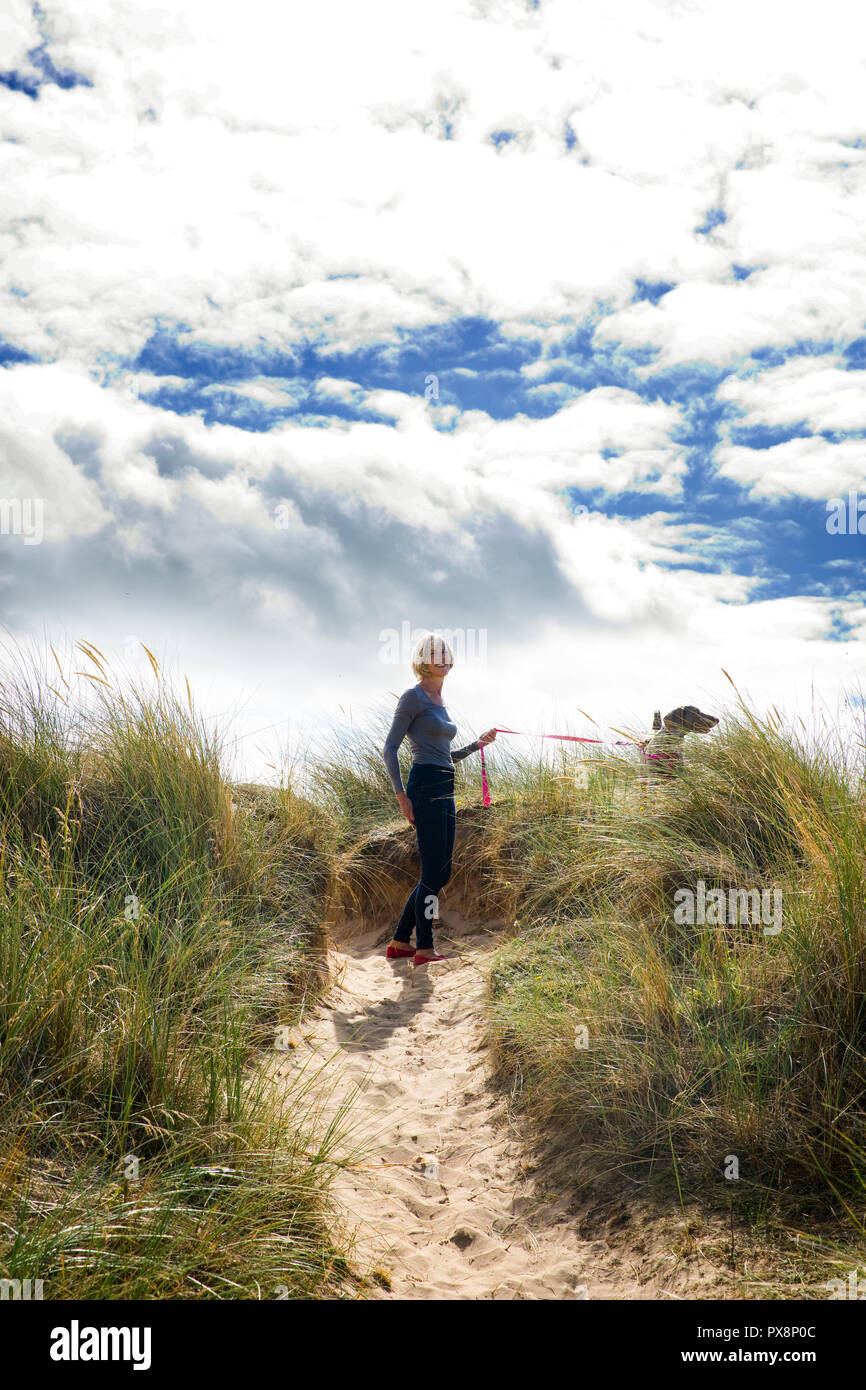 Wandern mit Hund in den Dünen bei Thornham, Norfolk, England Stockfoto