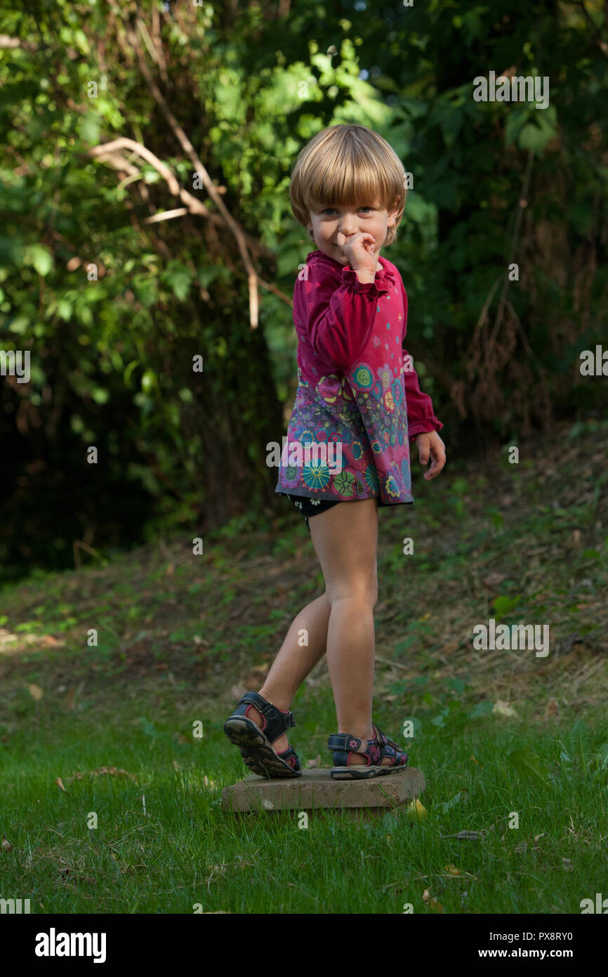 Kleine blonde Mädchen auf dem Spielplatz im Freien. Stockfoto