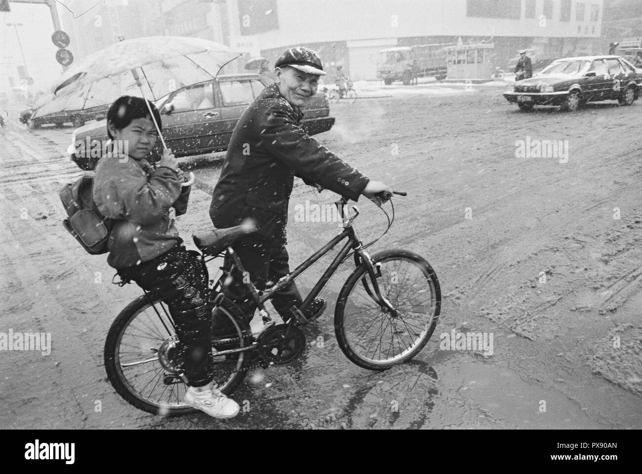 (181020) - Peking, Oktober 20, 2018 (Xinhua) - Foto 1994 zeigt einen Mann, der ein Kind mit dem Fahrrad in den Schnee in Qiqihar in die Schule genommen, im Nordosten der chinesischen Provinz Heilongjiang. Wenn sie nach Peking kam, der Hauptstadt von China, vor 40 Jahren, sie wurden wahrscheinlich durch die von ea in der Fahrräder" auf der Straße getroffen, ein einzigartiges Phänomen verdienen China den Titel "Königreich der Fahrräder". Damals gewöhnlichen chinesischen konnte es sich nicht leisten, Autos und nur wenige Menschen konnten fahren, geschweige denn häufig Fern- Reisen. Züge, die am häufigsten Verkehrsmittel dann, waren immer Stau - in der stickigen Co verpackt Stockfoto