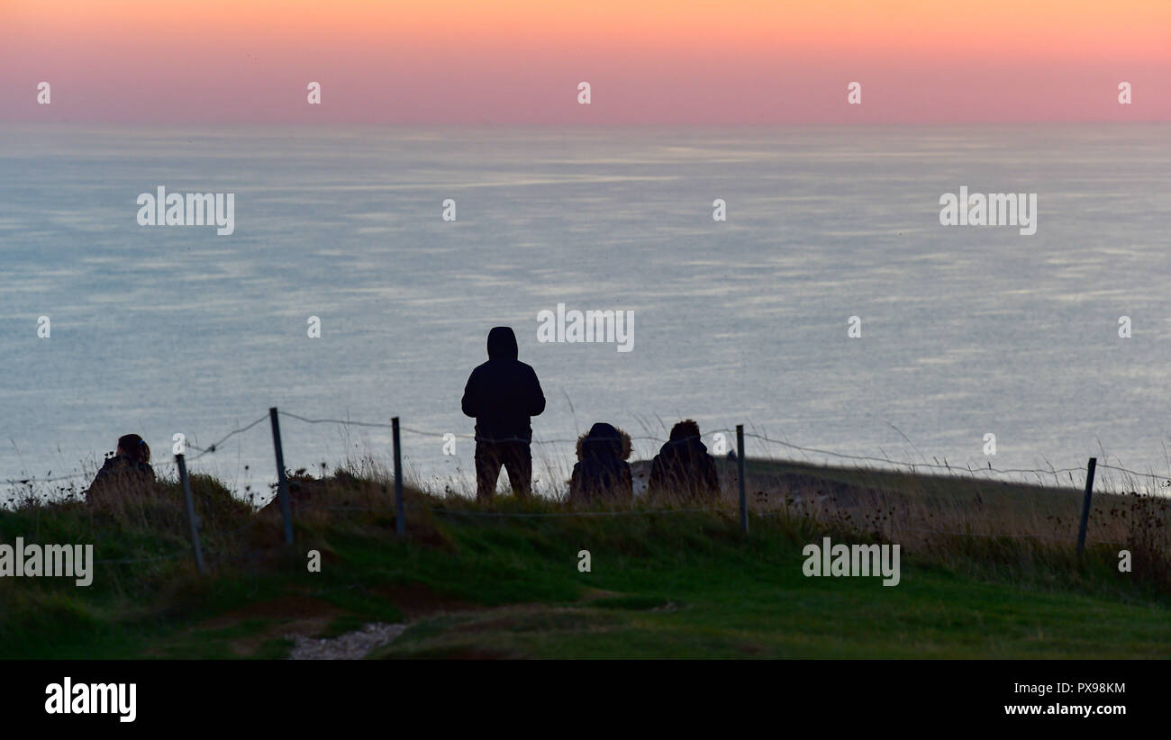 Eastbourne, Großbritannien. Okt, 2018 20. Besucher erhalten nahe an den Rand der Klippen der Sonnenuntergang von Beachy Head an diesem Abend zu beobachten, nach einem weiteren Tag der warmen sonnigen Wetter an der Südküste: Simon Dack/Alamy leben Nachrichten Stockfoto