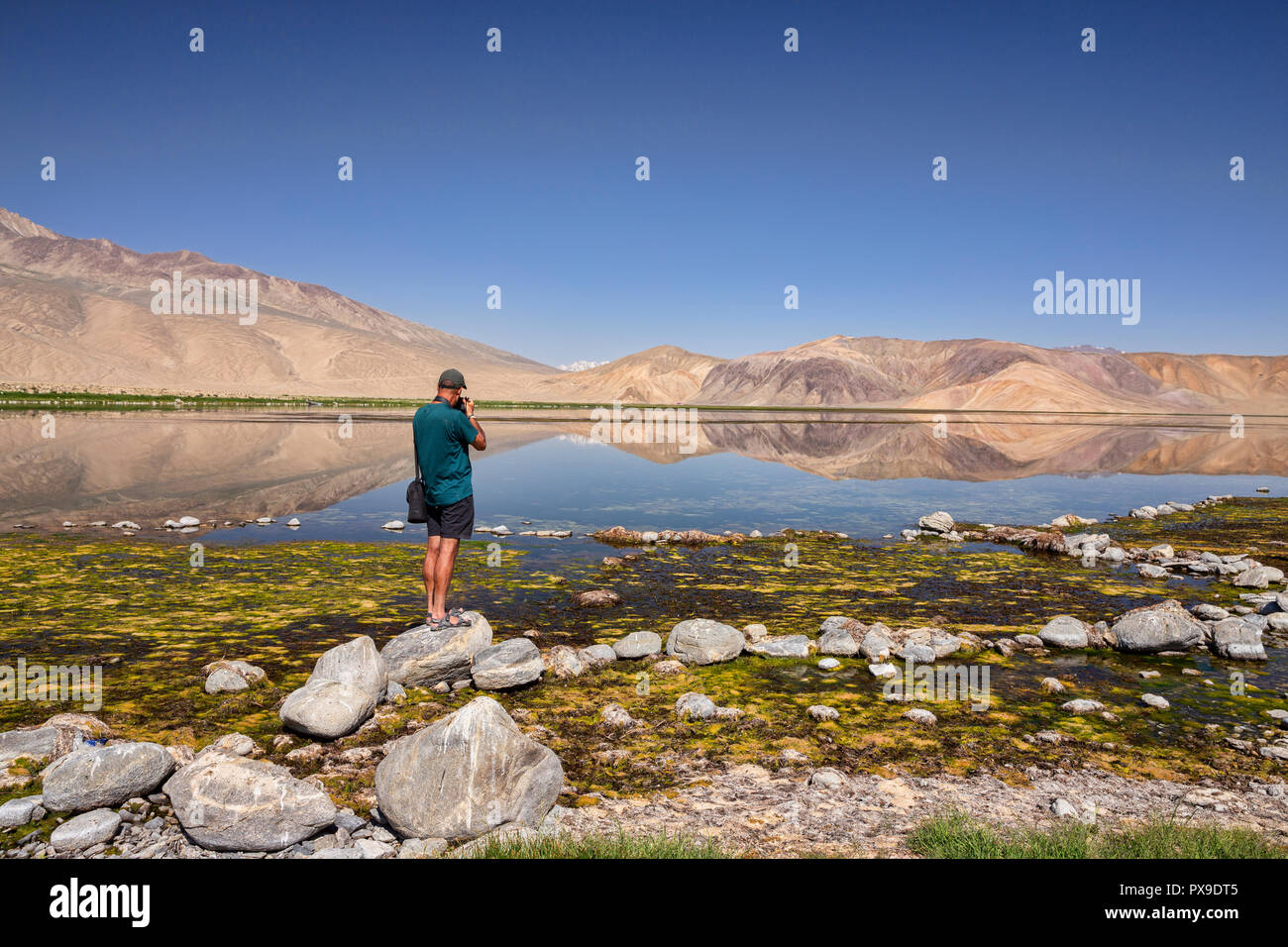 Fotograf schießt Foto von Berg Reflexionen in schönen Bulunkul See, Obere Gunt Tal, Pamir, Gorno Badkhshan, Tadschikistan Stockfoto