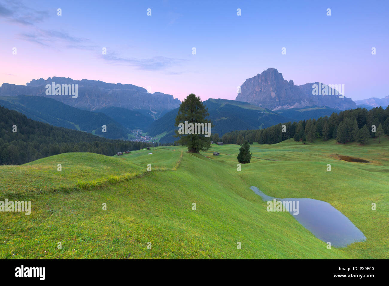 Sonnenaufgang über Langkofel und Sella Gruppe mit einem saisonal geöffneten Pool im Vordergrund. Daunei, Wolkenstein in Gröden, Gröden, Südtirol, Dolomiten, Stockfoto