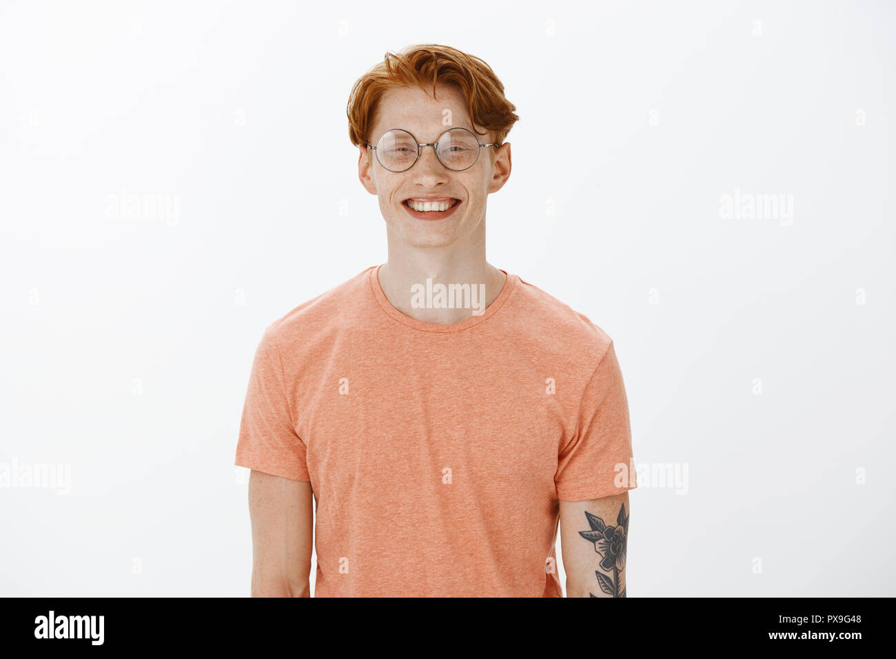 Freut mich. Smart attraktive rothaarige Menschen mit Sommersprossen und Tätowierungen, lächelnd mit freundlich und froh, Ausdruck, neue Leute treffen bei der Arbeit Stockfoto