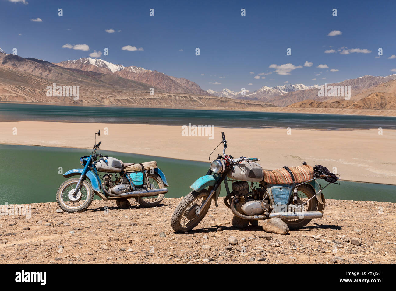 Paar alte russische Motorräder an Yashikul See im oberen Gunt Tal, Pamir, Tadschikistan geparkt Stockfoto