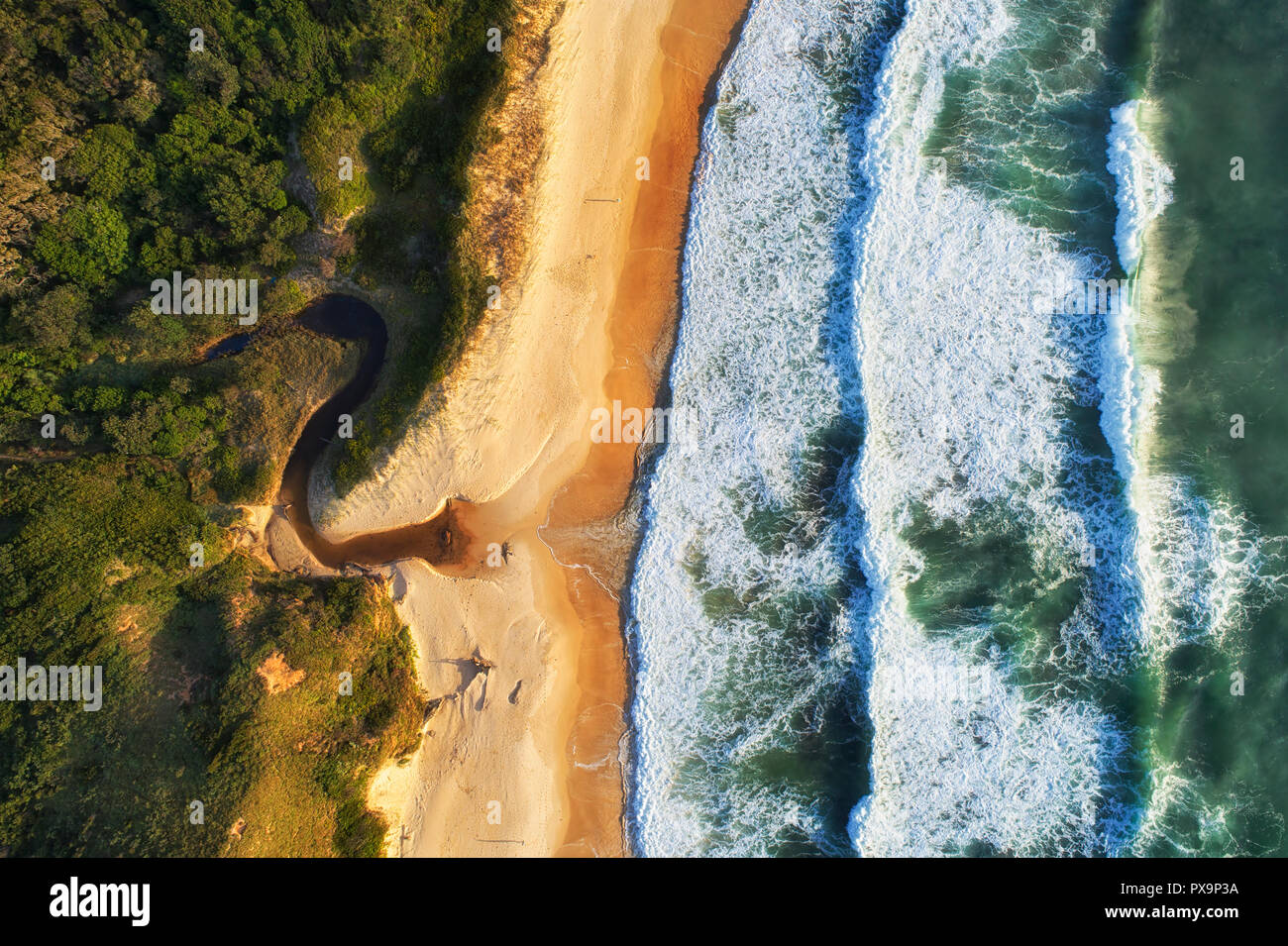 Kleine streaming Creek in endlosen Pazifik drücken Wellen in Richtung Sandstrand in Nambucca Heads Küste - von oben, von oben nach unten suchen. Stockfoto
