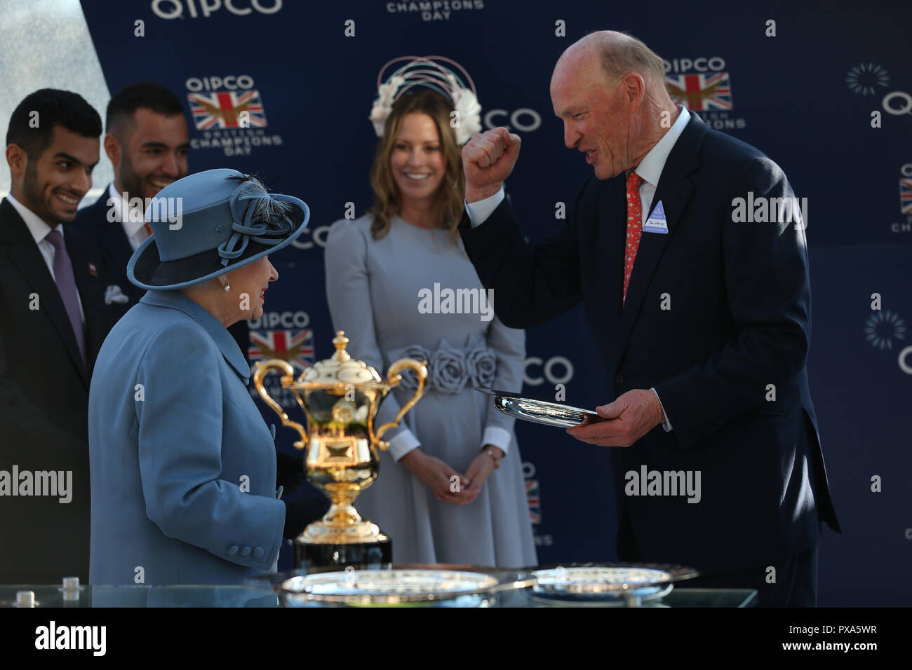 Queen Elizabeth II präsentiert Trainer John gosden mit seiner Trophäe nach brüllender Löwe, die Queen Elizabeth II Stakes Rennen während QIPCO britische Champions Day in Ascot Rennbahn laufen gewonnen. Stockfoto