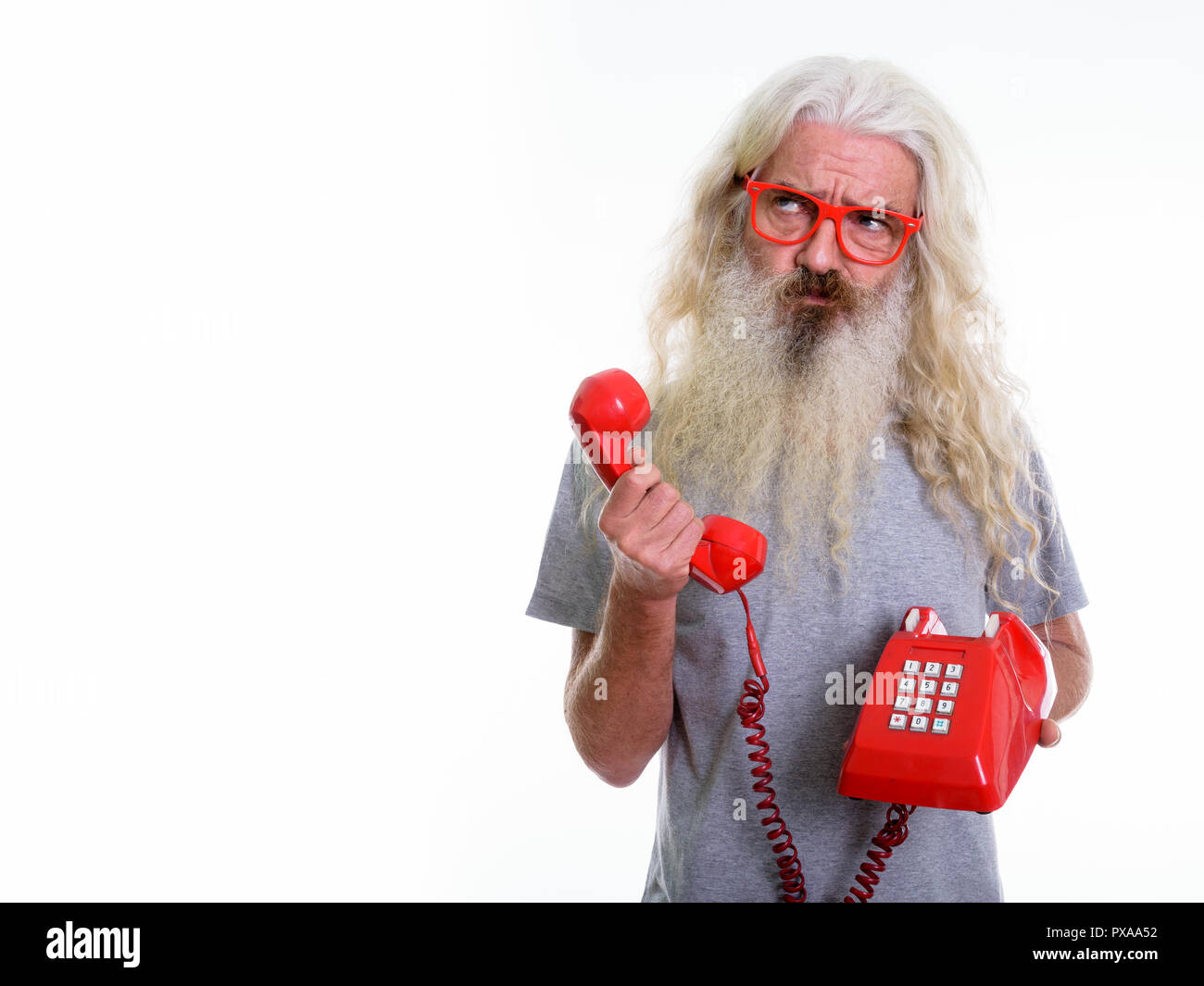 Studio shot der älteren bärtigen Mann mit alten Telefon während Th Stockfoto