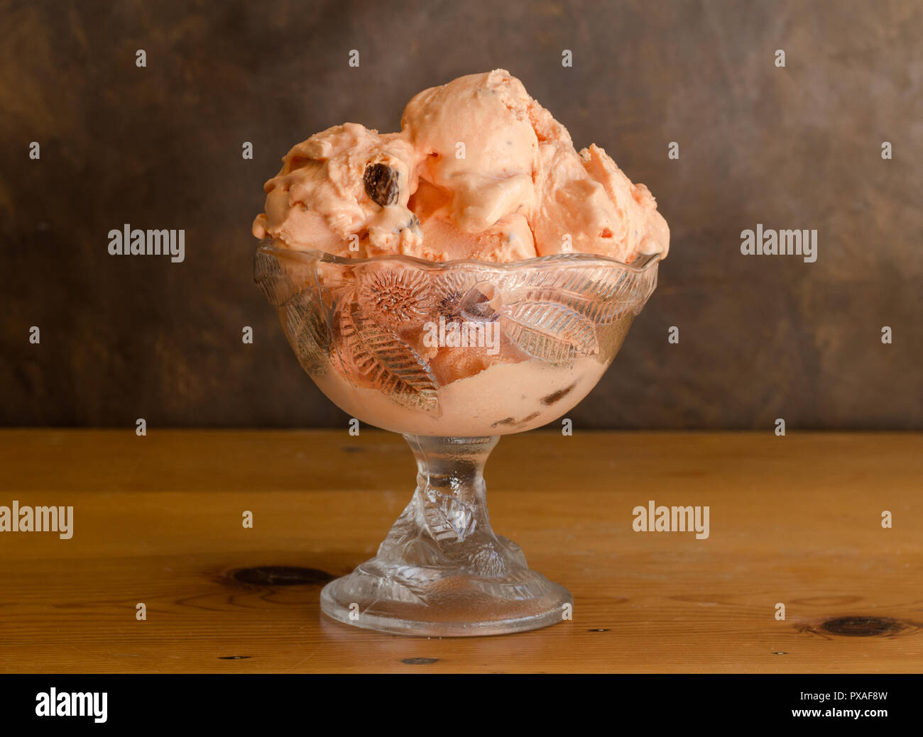 Rum und Rosinen icecream in Glasschale auf rustikalen Holztisch Stockfoto