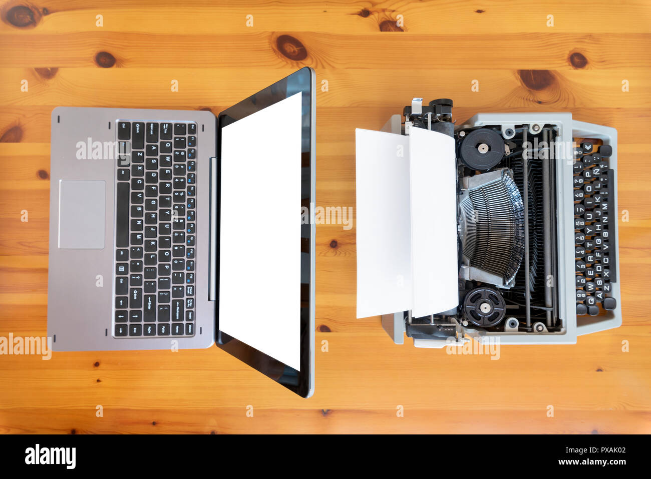 Alte Schreibmaschine vs neue Laptop auf dem Tisch. Konzept der Technologie Fortschritt. Stockfoto