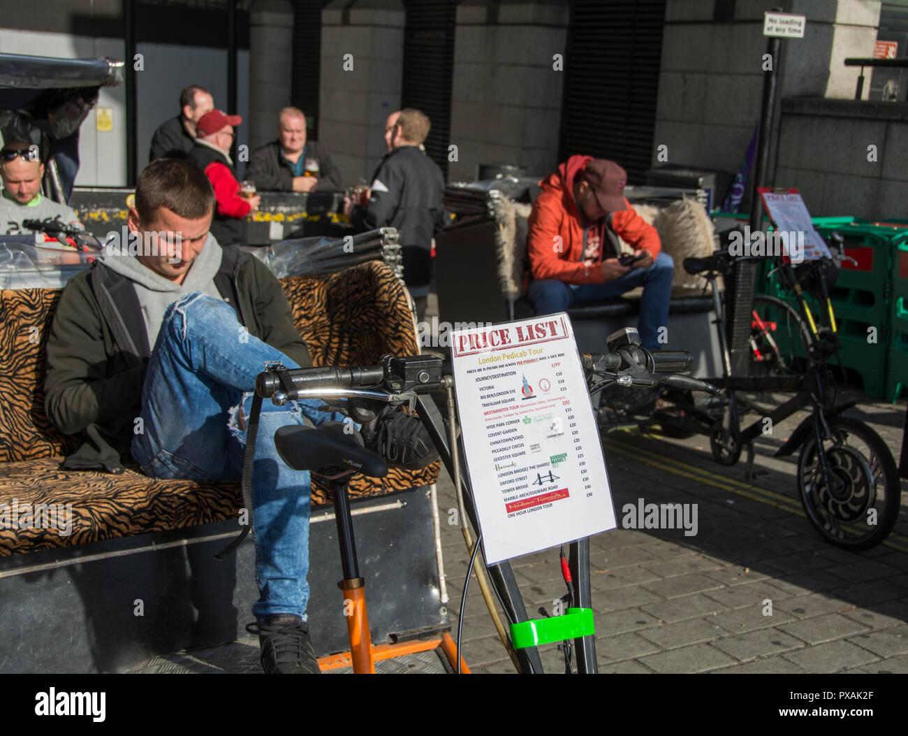 Tarife für London Rikscha Fahrer warten können außerhalb des Houses of Parliament, London, UK Stockfoto