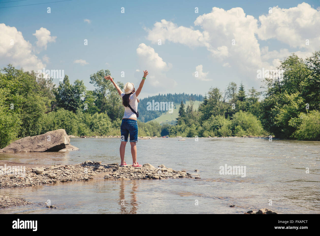 Stehendes Mädchen am Ufer des Flusses Stockfoto