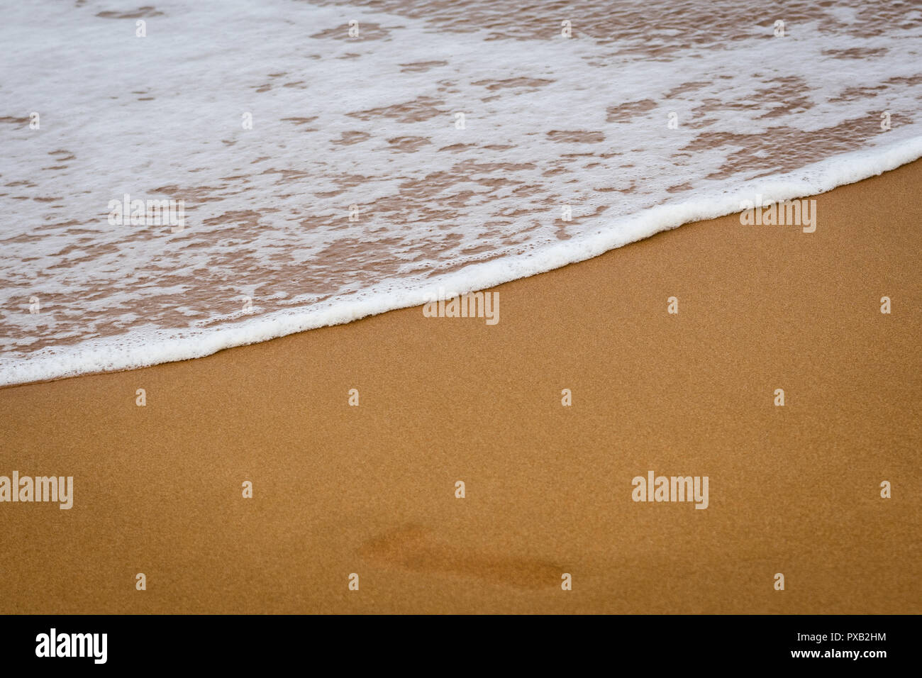 Welle auf dem Sand strand Hintergrund bei Ramla Bay Gozo. Berühmte touristische Strand in Malta. soft Wave auf dem roten Sand. Stockfoto