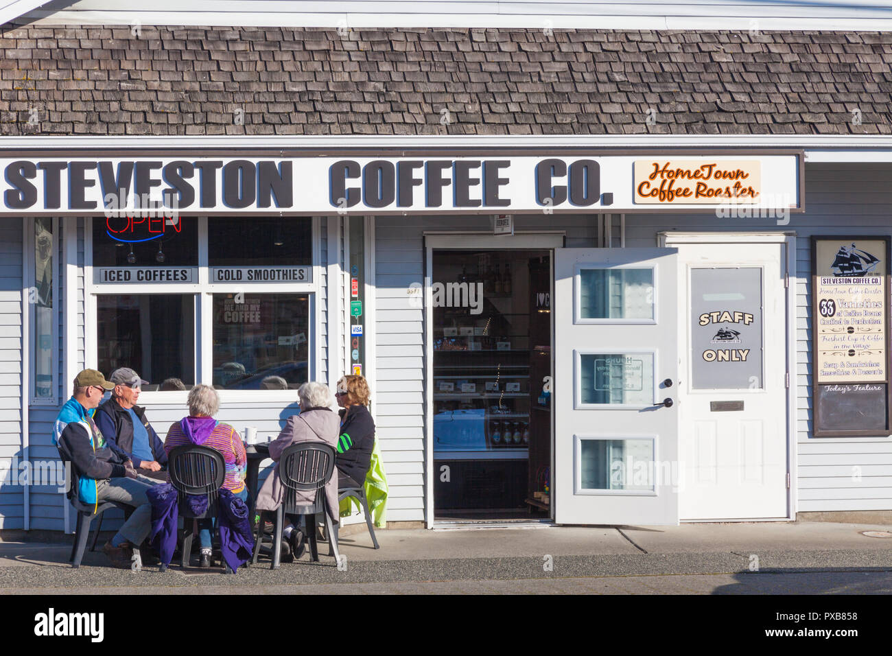Kunden genießen Herbst Sonnenschein und Kaffee in Steveston Dorf British Columbia Stockfoto