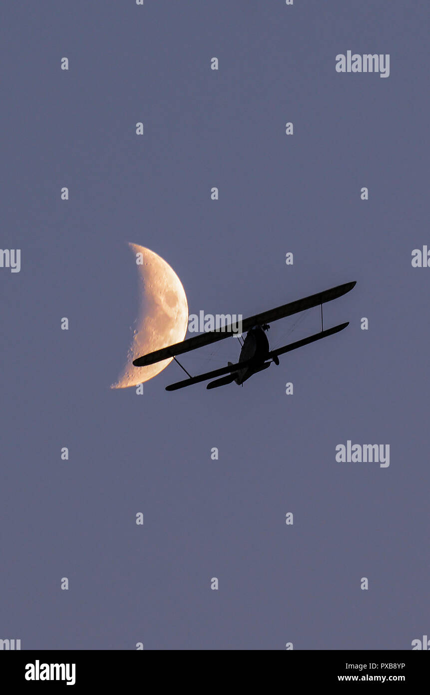 Hawker Cygnet replica vintage Doppeldecker fliegen in der Dämmerung mit dem Mond darüber hinaus. 1920 Doppeldecker ultraleicht Design von Sidney Camm. Leichte Flugzeuge Stockfoto