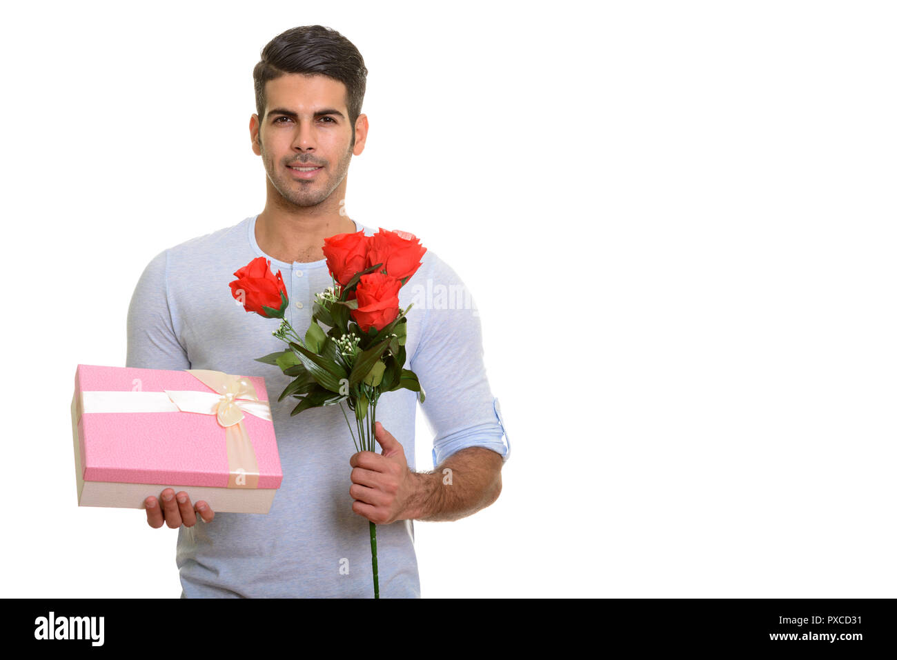 Junge glücklich Persischen Mann lächelnd, während sie Geschenkbox und Rot r Stockfoto
