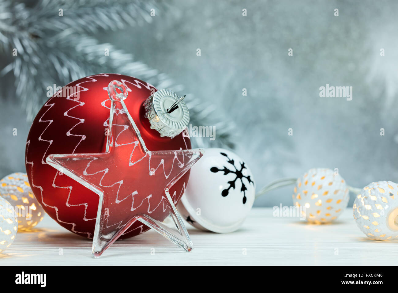 Red christmas Ball, Girlanden und dekoratives Glas Stern auf defokussierten Hintergrund grau mit Fir Tree Branch Stockfoto