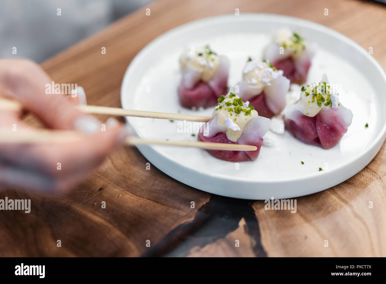 Chinesische und Koreanische Knödel auf dem weißen Teller mit Pistazien eingerichtet. Stockfoto