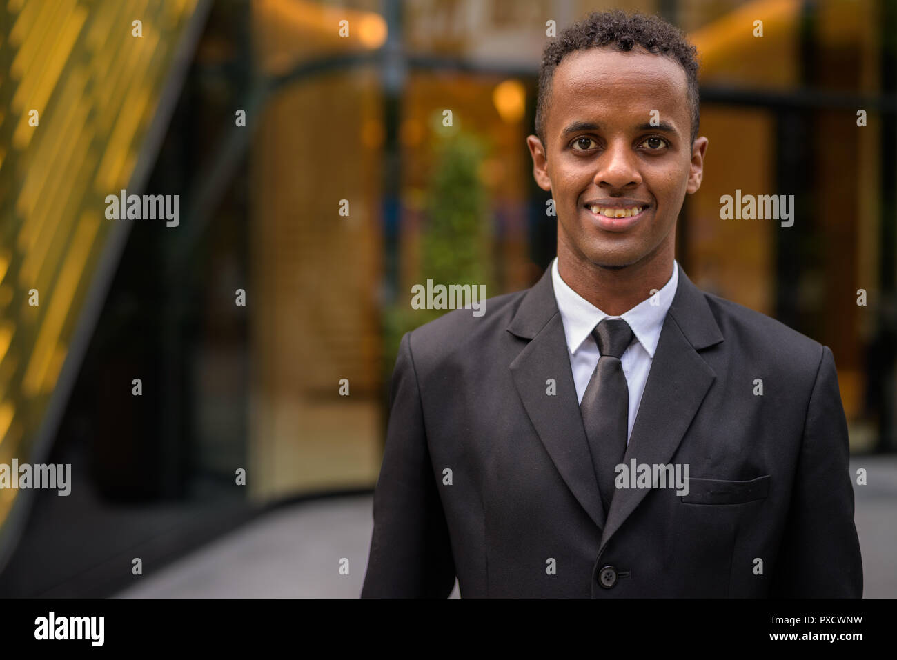 Porträt der jungen afrikanischen Geschäftsmann lächelnd im Freien Stockfoto