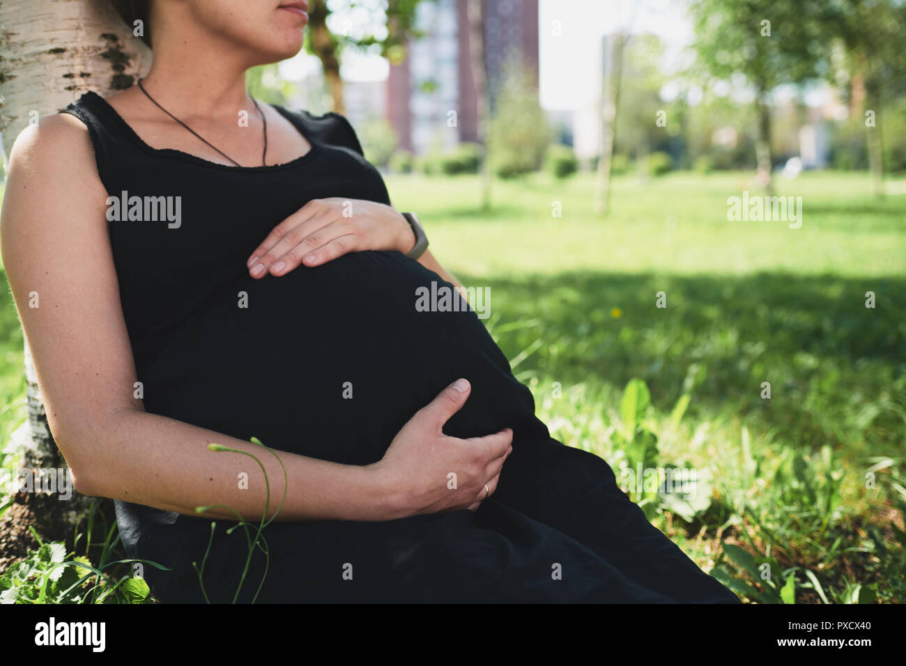 Schwangere Frau im schwarzen Kleid Stockfoto